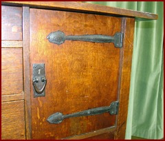 Close-up of door on right side showing the hand hammered copper strap hinges and door pull.